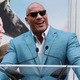 Dwayne "The Rock" Johnson in a blue suit and sunglasses